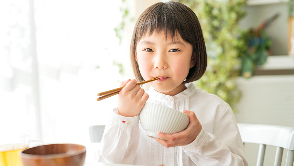 しっかり朝ごはんを食べる子供